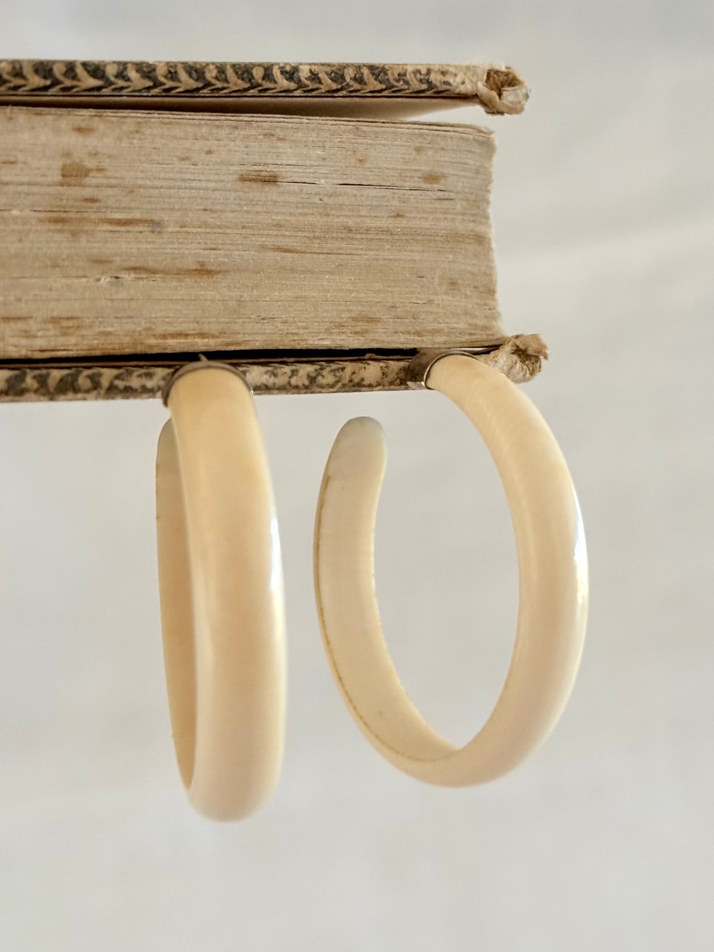 .1950s .1960s classic and gorgeous oversized pre ban Ivory hoop huggies capped in silver